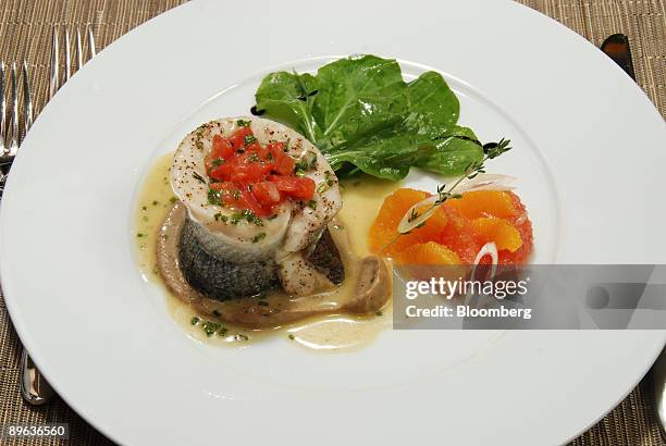 Poached filet of branzino with tomato concasse, blood orange salad, extra virgin olive oil and eggplant licorice coulis is shown at Montenapo...