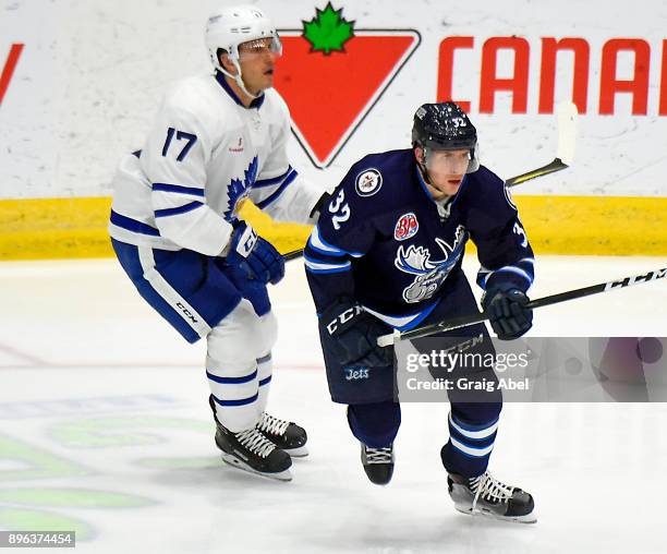 Jansen Harkins of the Manitoba Moose turns up ice against Richard Clune of the Toronto Marlies during AHL game action on December 17, 2017 at Ricoh...