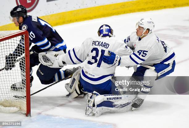 Miro Aaltonen and Calvin Pickard try to stop Buddy Robinson of the Manitoba Moose during AHL game action on December 17, 2017 at Ricoh Coliseum in...