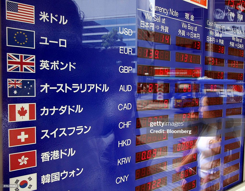 A woman is reflected in an electronic board displaying the c