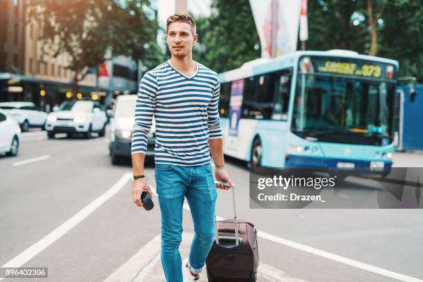 man with suitcase waiting for public transport - traffic australia stock pictures, royalty-free photos & images