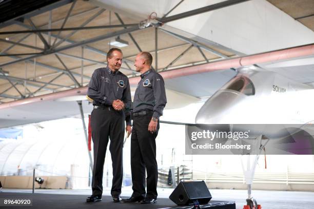 Bertrand Piccard, right, and Andre Borschberg, both pilots and co-founders of the Solar Impulse project, shake hands during the unveiling of the...