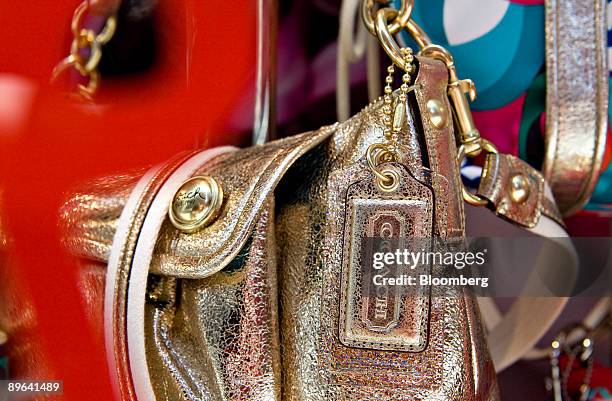 Coach handbag sits on display in the window of a Coach store in New York, U.S., on Monday, July 6, 2009. Consumers are coping with the recession by...