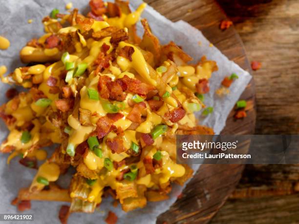 loaded blooming onion with fries, cheese sauce and bacon - allium flower imagens e fotografias de stock