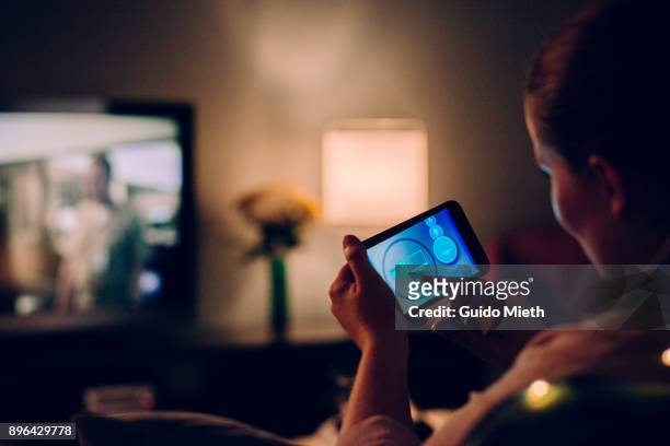 woman using mobile app at home. - tv program stockfoto's en -beelden