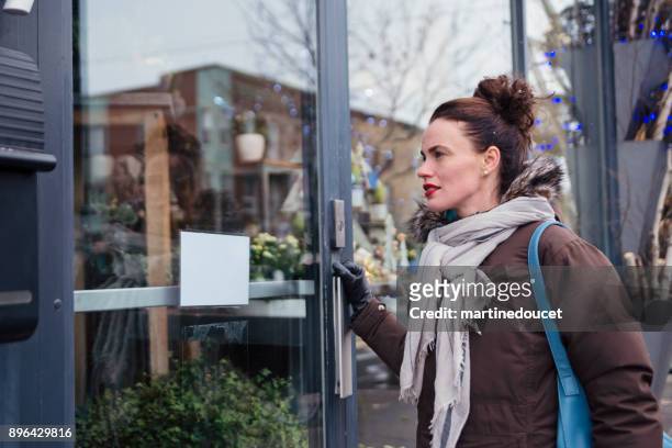 woman getting in a city store in winter. - entering shop stock pictures, royalty-free photos & images