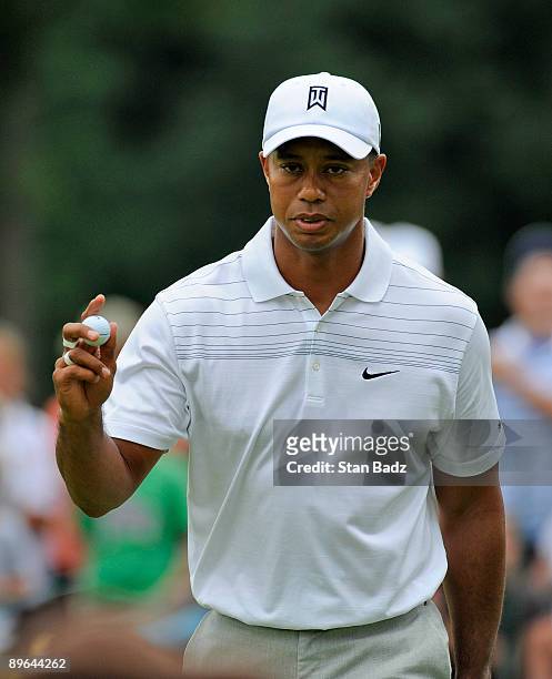 Tiger Woods waves his ball at the sixth green during the first round of the World Golf Championships-Bridgestone Invitational held at Firestone...