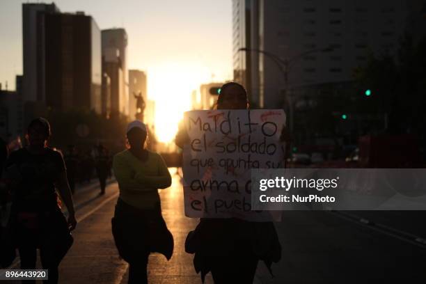 Demonstrator holds a banner while marching to protest against the Law of Internal Security, a law that militarizes crime fighting in the country,...