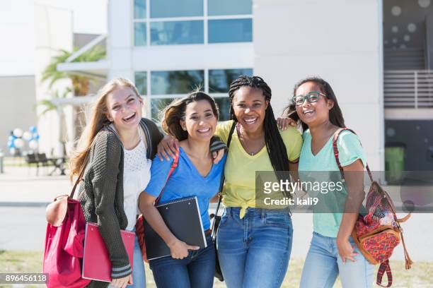 four multi-ethnic teenage students on campus - female high school student stock pictures, royalty-free photos & images