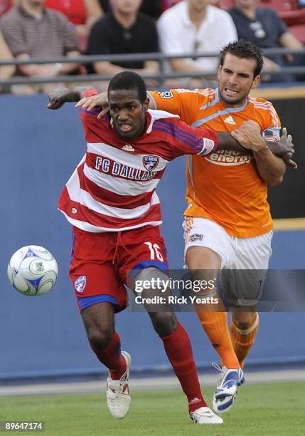 Atiba Harris of the FC Dallas runs the ball away from Mike Chabala of the Houston Dynamo at Pizza Hut Park August 6, 2009 in Frisco, Texas.