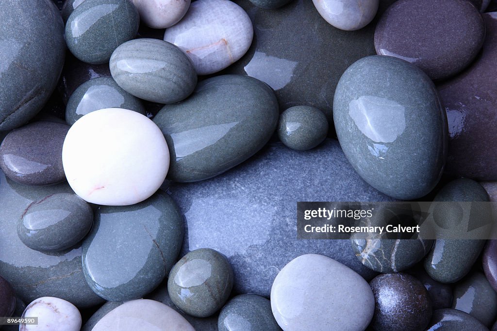 Wet granite pebbles on beach.