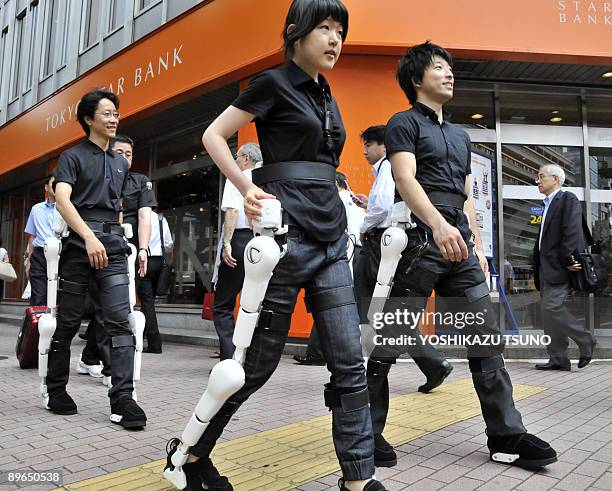 Japan's robotics venture Cyberdyne employee wearing the robot-suit "HAL" walk on a street in Tokyo for the demonstration on August 3, 2009. Tsukuba...