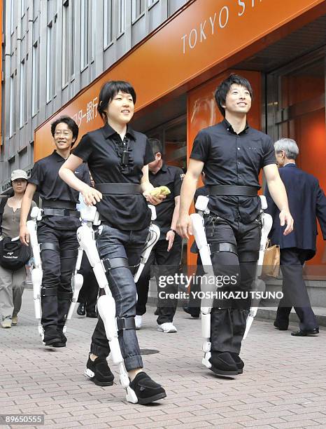 Japan's robotics venture Cyberdyne employee wearing the robot-suit "HAL" walk on a street in Tokyo for the demonstration on August 3, 2009. Tsukuba...