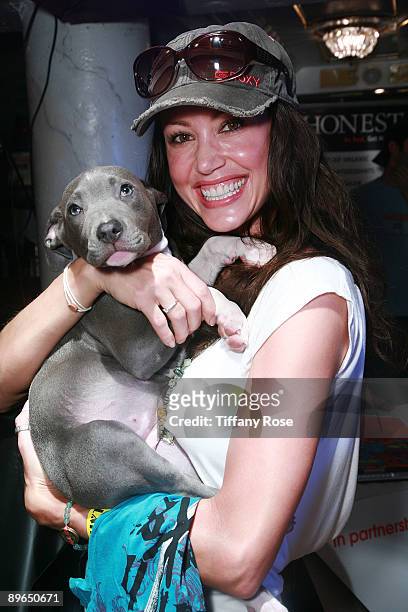 Actress Shannon Elizabeth poses with a puppy from Tails of the City Animal Rescue at Melanie Segal's Teen Choice Lounge Presented by Rocket Dog at...