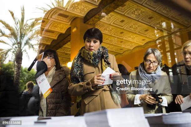 Voters collect ballot papers as voting gets underway in the Catalonia regional election at polling station in the Industrial School of Barcelona in...