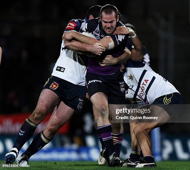 Scott Anderson of the Storm is tackled during the round 22 NRL match between the Melbourne Storm and the North Queensland Cowboys at Olympic Park on...