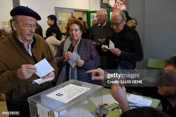 Man prepares to cast his ballot for the Catalan regional election at a polling station in Barcelona on December 21, 2017. Catalans take their...