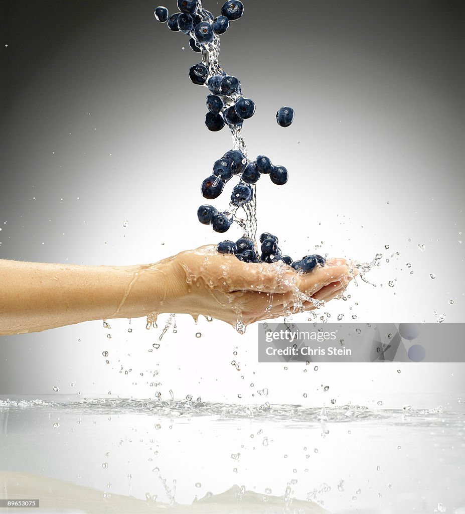 Woman tossing blueberries in the air