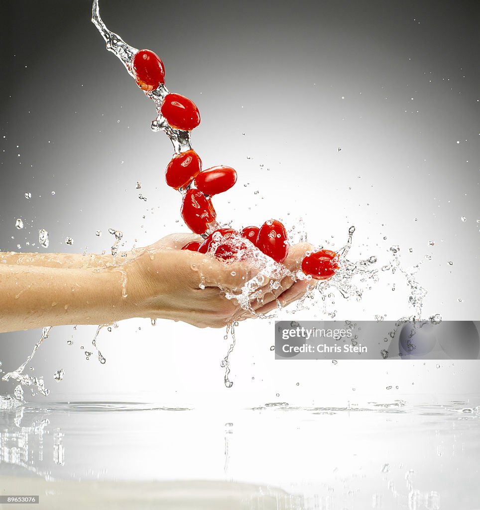 Woman tossing plum tomatoes