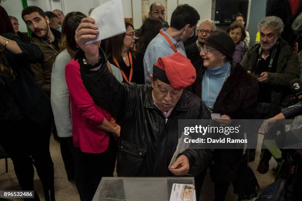 Voter wearing a traditional Catalan hat known as 'Barretina' waves his ballot before casting it on December 21, 2017 in Barcelona Spain.Catalan...