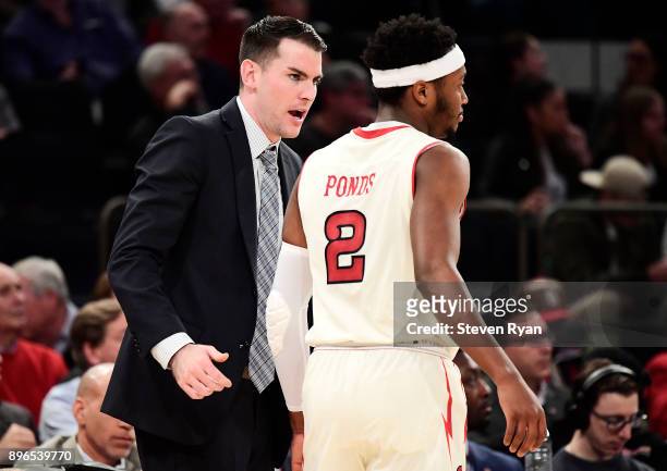 Assistant coach Greg St. Jean of the St. John's Red Storm speaks with Shamorie Ponds against the Iona Gaels during an NCAA men's basketball game at...