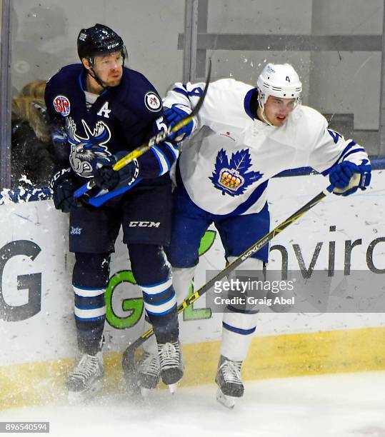 Justin Holl of the Toronto Marlies battles with Cameron Schilling of the Manitoba Moose during AHL game action on December 17, 2017 at Ricoh Coliseum...