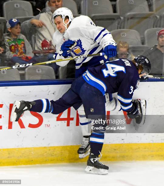 Lipon of the Manitoba Moose puts a hit on Michael Paliotta of the Toronto Marlies during AHL game action on December 17, 2017 at Ricoh Coliseum in...