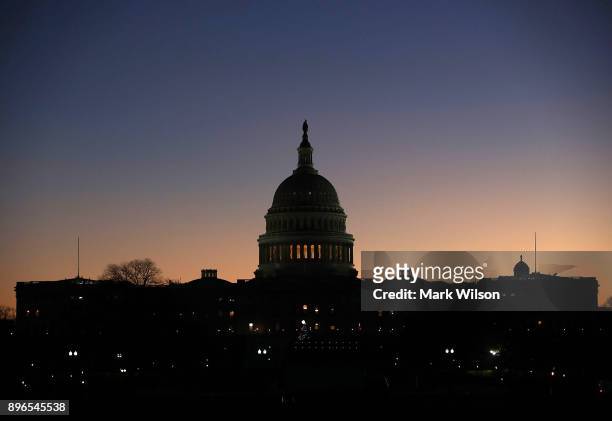 The early morning sun begins to rise behind the U.S. Capitol as Congressional law makers work on a deal to fund the government to avert a shutdown by...