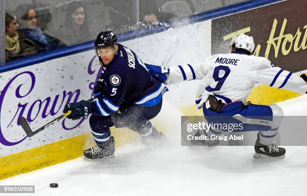 Cameron Schilling of the Manitoba Moose controls the puck against Trevor Moore of the Toronto Marlies during AHL game action on December 17, 2017 at...