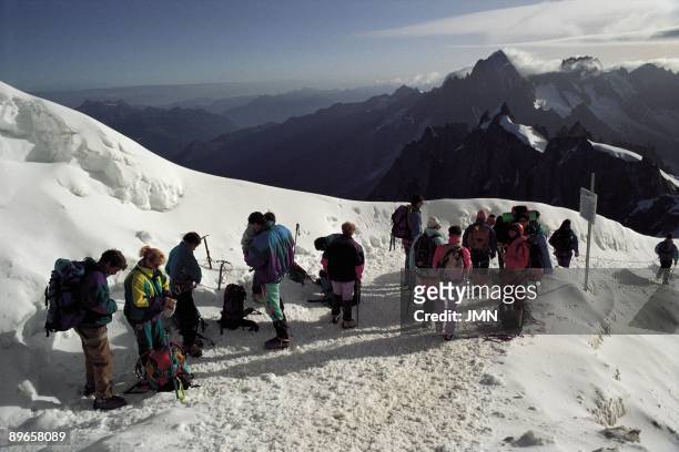 Route to the Mont Blanc A group of mountaineer cover a distance between Aiguille du Midi and the Mont Blanc, France Alps