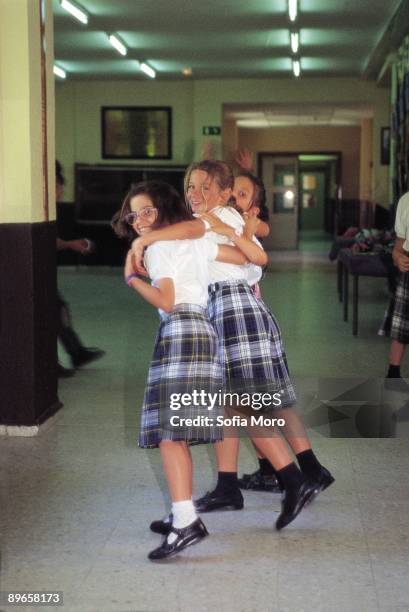 Girls smile in a school Three girls smile in one of the corridors of the school King´ s Collage of Madrid