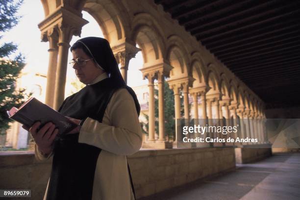 Monastery of San Andres del Arroyo A nun reads in a cloister of Monastery of San Andres del Arroyo . 12th to 18th centuries. Cistercian. Palencia...