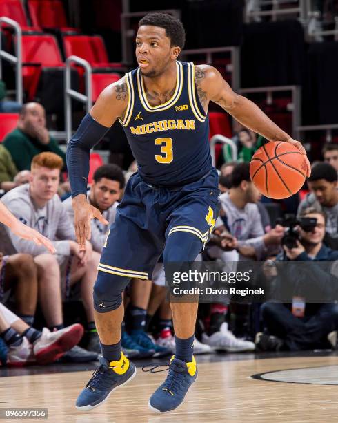 Zavier Simpson of the Michigan Wolverines controls the ball against the Detroit Titans during game one of the Hitachi College Basketball Showcase at...