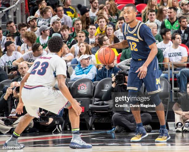 Josh McFolley of the Detroit Titans defends against Muhammad-Ali Abdur-Rahkman of the Michigan Wolverines during game one of the Hitachi College...