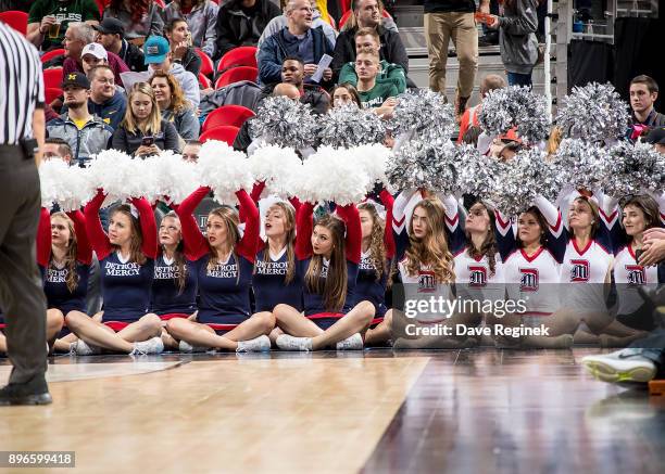 The Detroit Titans cheer team hold up their pom poms on a free throw attempt by the Michigan Wolverines during game one of the Hitachi College...