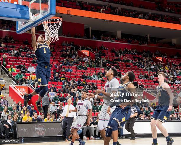 Charles Matthews of the Michigan Wolverines goes up for a slam dunk against the Detroit Titans during game one of the Hitachi College Basketball...