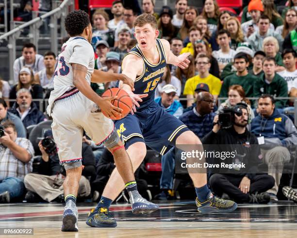 Jon Teske of the Michigan Wolverines defends against Josh McFolley of the Detroit Titans during game one of the Hitachi College Basketball Showcase...