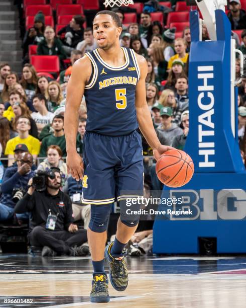 Jaaron Simmons of the Michigan Wolverines controls the ball against the Detroit Titans during game one of the Hitachi College Basketball Showcase at...