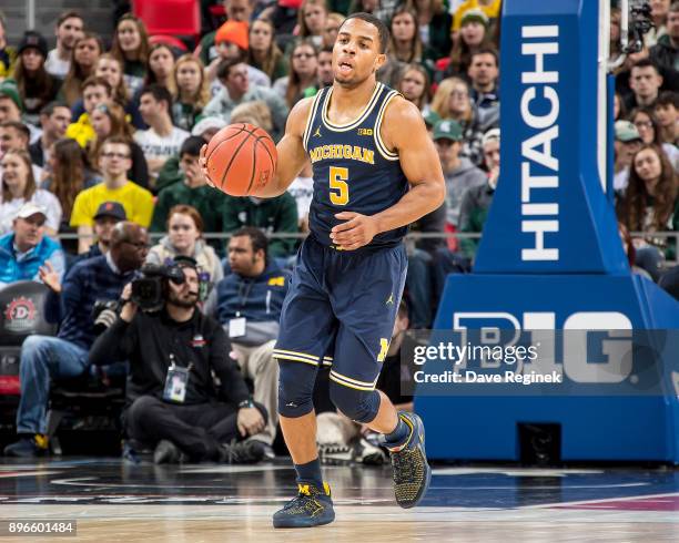 Jaaron Simmons of the Michigan Wolverines controls the ball against the Detroit Titans during game one of the Hitachi College Basketball Showcase at...