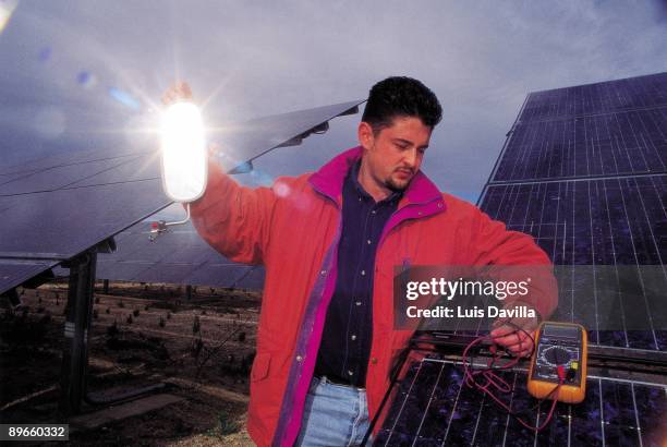 Solar panels A man revises with a machine the sun pannels of a a photovoltaic power station of Toledo
