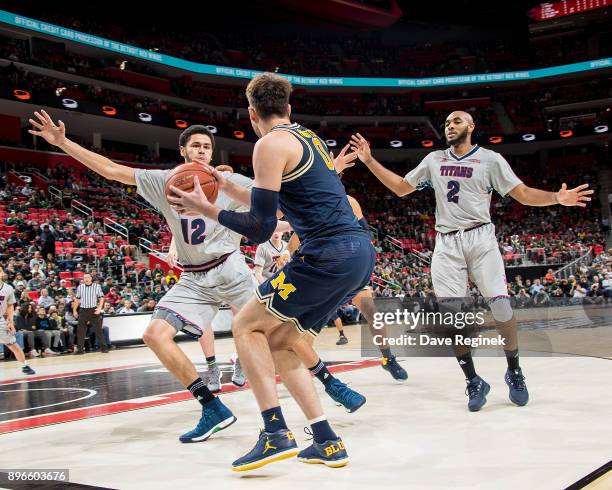 Brent Hibbitts of the Michigan Wolverines controls the ball in front of Malik Eichler and Roschon Prince of the Detroit Titans during game one of the...