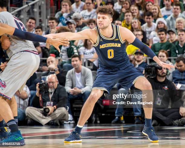 Brent Hibbitts of the Michigan Wolverines defends against the Detroit Titans during game one of the Hitachi College Basketball Showcase at Little...