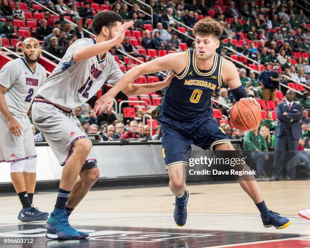 Brent Hibbitts of the Michigan Wolverines drives to the basket against Malik Eichler of the Detroit Titans during game one of the Hitachi College...