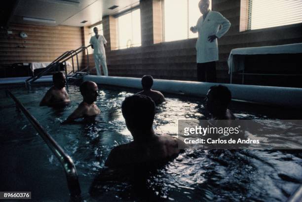 Exercises of rehabilitation in a pool People making rehabilitation exercises in a pool controlled by doctors