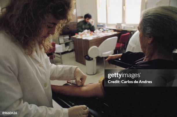 Doctor making an analysis of blood A doctor carries out an analysis of blood in a rural national health clinic