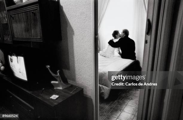 Even newlywed kissing one another View of an even newlywed kissing one another on the bed of their bedroom