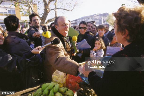 Manuel Fraga in a PP campaign for the Galician autonomic elections. A woman offers fruit to the president of the PP in a market