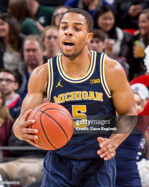 Jaaron Simmons of the Michigan Wolverines controls the ball against the Detroit Titans during game one of the Hitachi College Basketball Showcase at...