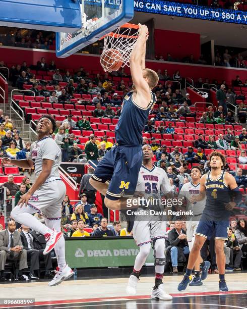 Austin Davis of the Michigan Wolverines slam dunks the ball against the Detroit Titans during game one of the Hitachi College Basketball Showcase at...