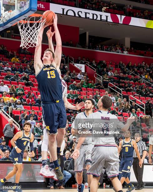 Jon Teske of the Michigan Wolverines grabs the rebound against the Detroit Titans during game one of the Hitachi College Basketball Showcase at...